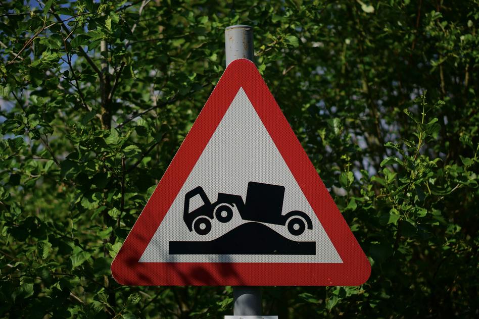 Cartello stradale con un camion incastrato su una cunetta